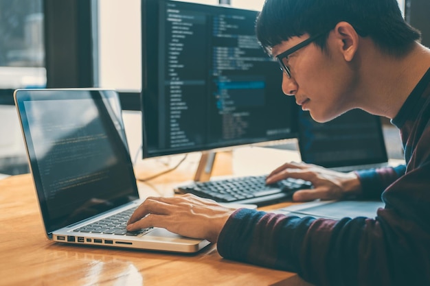 Side view of businessman using laptop at desk in office