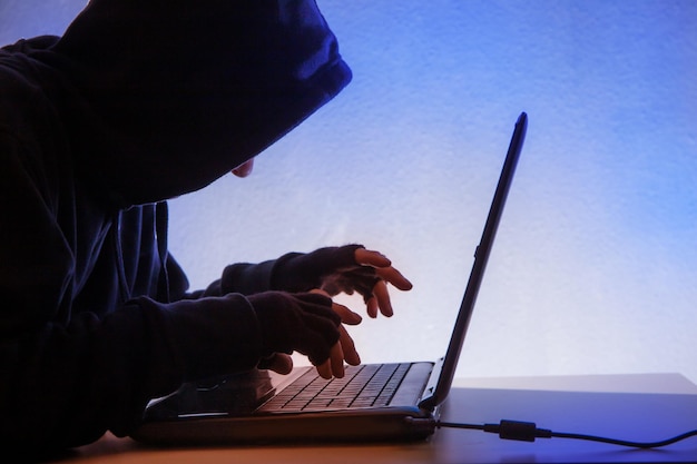 Side view of thief using laptop on table