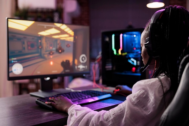 Sisällöntuottaja pelaa online-moninpelivideopeliä tietokoneasemalla ja kilpailee suorassa esports-turnauksessa. Afrikkalaisamerikkalainen nainen striimaa peliä faneille, jotka katsovat kotona