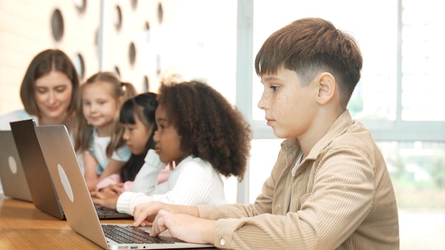 Smart boy playing laptop with multicultural friend learning prompt Erudition