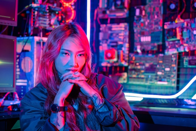 Smiling young woman wearing black jacket to do playing live stream games online at home Portrait of happy gamer endeavor plays online video games tournament with computer neon light