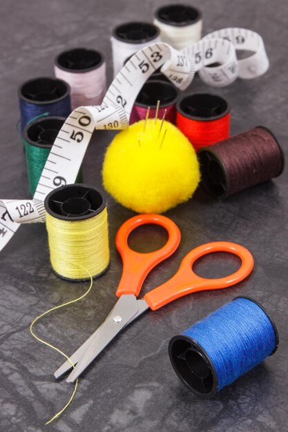 Spools of colorful thread needle tape measure and scissors Accessories for sewing and needlework