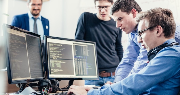Startup-yrityksen ongelmanratkaisu. Ohjelmistokehittäjät työskentelevät pöytätietokoneella