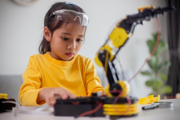 stem education concept asian students learn at home by coding robot arms in stem mathematics engineering science technology computer code in robotics for kids concepts