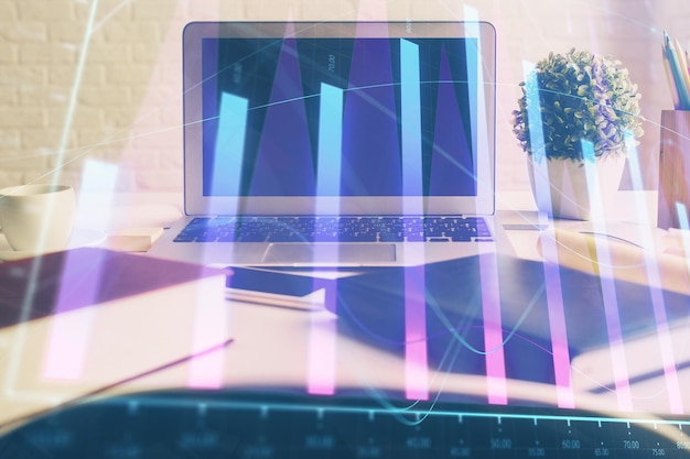 stock market graph on background with desk and personal computer double exposure concept of financial analysis