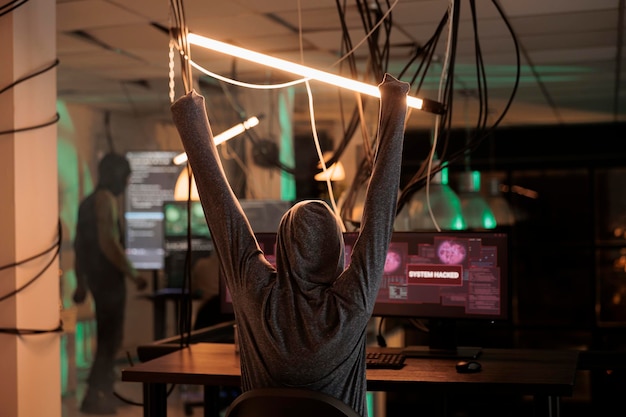 successful computer system password hacking, internet criminal celebrating victory. cyberattack, hacker raising hands, sending virus, breaking into database server, back view