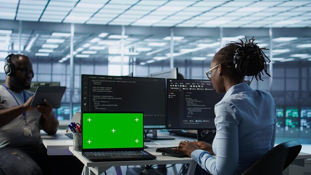Team of developers in server hub using green screen laptop