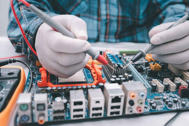 Technician repairing inside of hard disk by soldering iron.