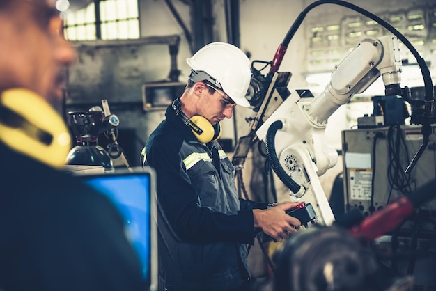 Tehdastyöntekijät työskentelevät taitavan robottikäden kanssa työpajassa