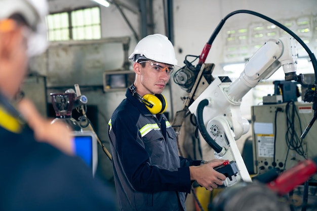 Tehdastyöntekijät työskentelevät taitavan robottikäden kanssa työpajassa