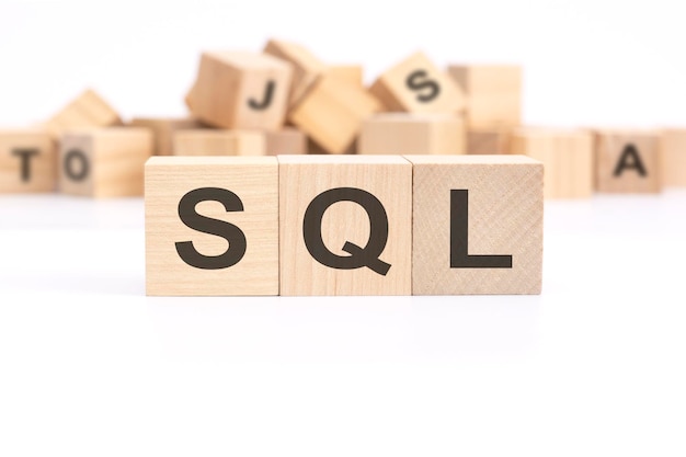 Text SQL sales qualified lead is written on three wooden cubes standing on a white table in the background a mountain of wooden cubes with letters