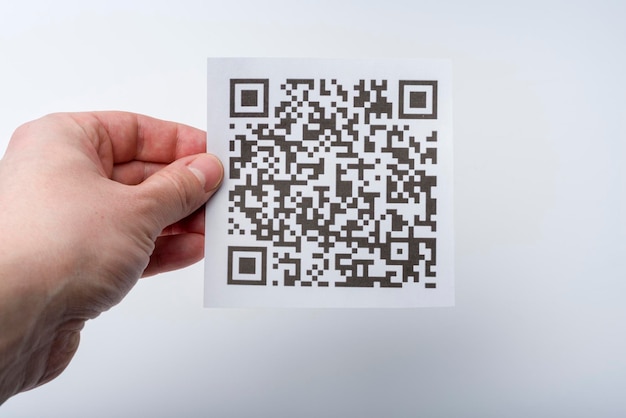 The hand holds the transaction code on a piece of paper