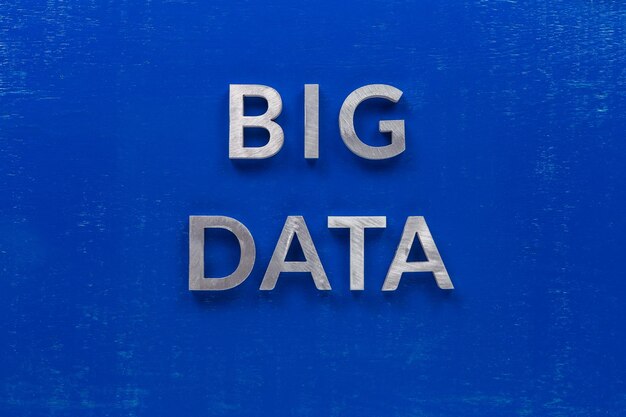 The words big data laid with silver metal characters on blue painted wooden board in central flat lay composition