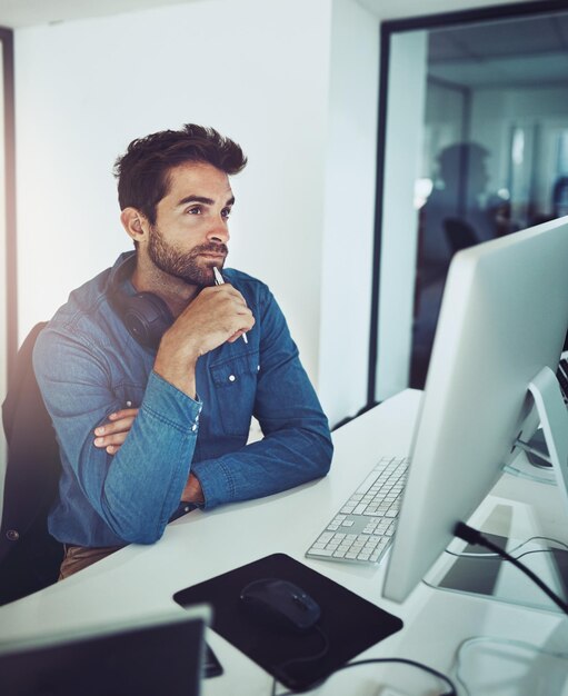 Thinking computer and business man with idea for decision inspiration or problem solving in creative startup Pc serious programmer and planning solution reflection or vision at desk for IT