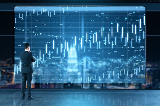 Thoughtful businessman standing in abstract office interior with glowing forex chart and night city view Trade and stats concept Double exposure
