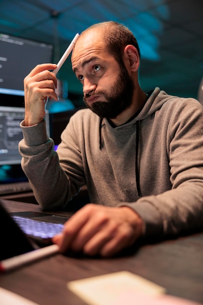 thoughtful developer brainstorming ideas to find source code and develop html script on terminal window. thinking about solution to create cloud computing server interface, coding program.