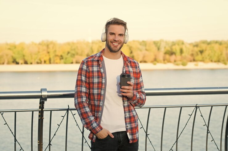 Kuva too early male casual hipster fashion man in headset listen song music style elearning while drinking coffee quality of sound good morning drink unshaven guy with coffee cup outdoor