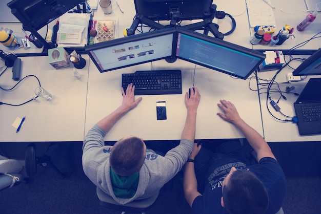 top view of software developers writing programming code on computer