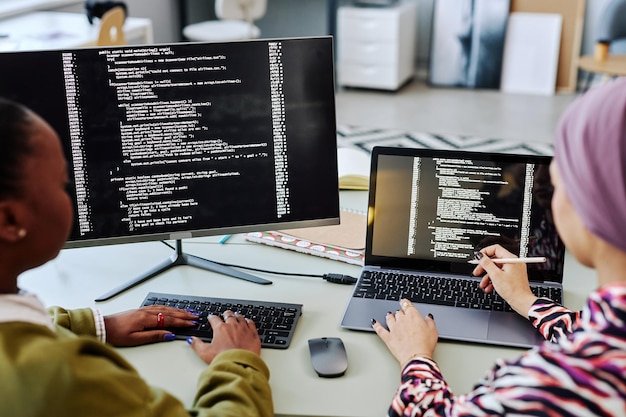 Two people writing code and reviewing project together