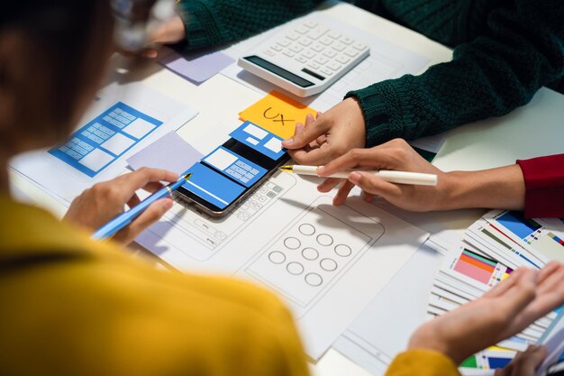 UX developer and ui designer brainstorming about mobile app interface wireframe design with customer breif and color code User experience concept
