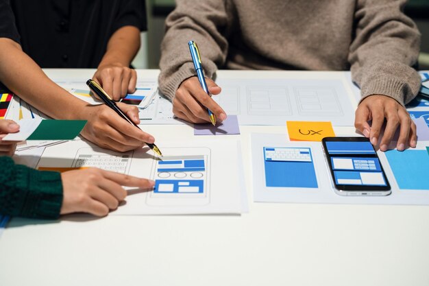 UX developer and ui designer brainstorming about mobile app interface wireframe design with customer breif and color code User experience concept