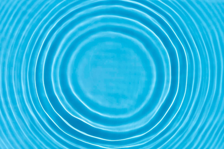 Kuva wave from a drop of water on blue water under natural light top view flat lay