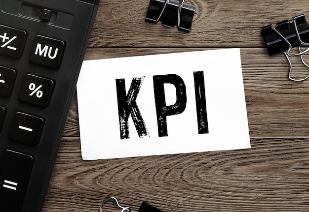 White card with text KPI with calculator on wooden background