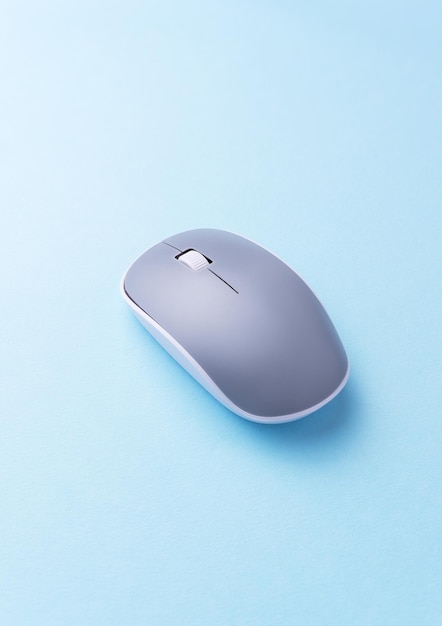 Wireless gray computer mouse over blue background