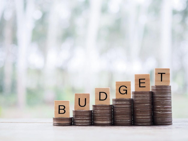 Wooden blocks with the word BUDGET on stack of coins The concept about budget planning and allocation