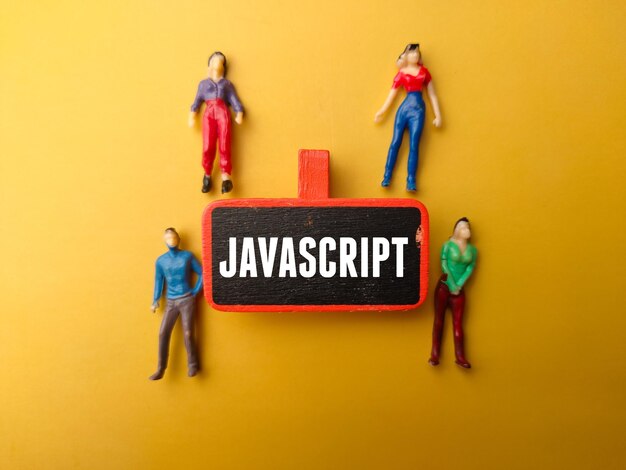 Wooden board and miniature people with text JAVASCRIPT on a yellow background