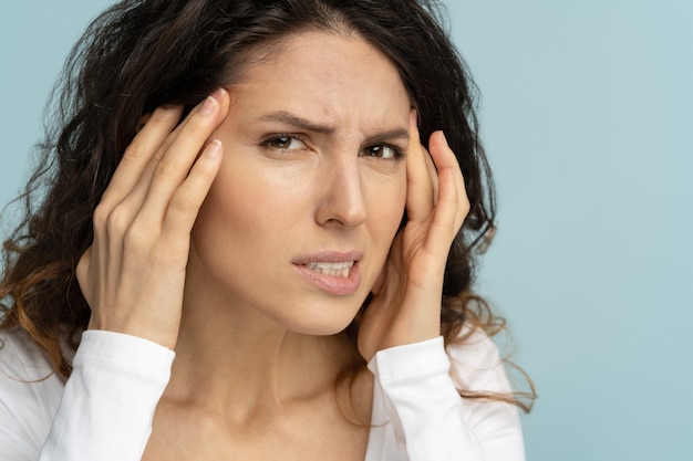 Worried woman without makeup has signs of aging skin, checking crows feet troubled with wrinkles on face