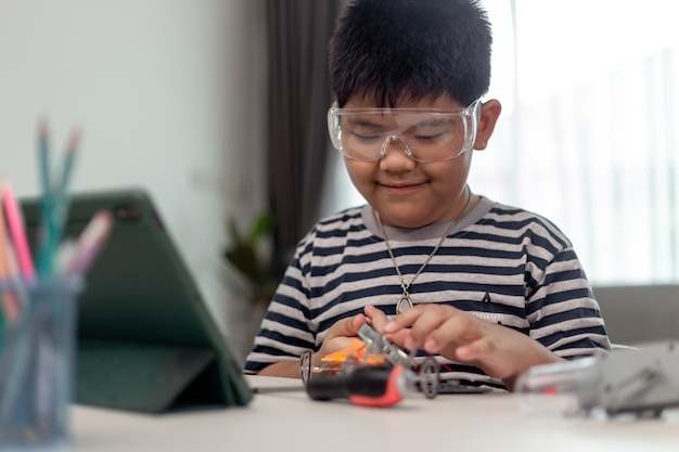 young asia student remotely learn online at home in coding robot car and electronic board cable in stem steam mathematics engineer science technology computer code in robotics for kids
