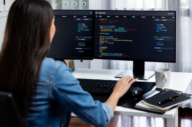 Young Asian in IT creating with typing online information on pc Stratagem
