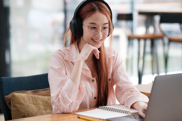 Young collage student using computer and mobile device studying online