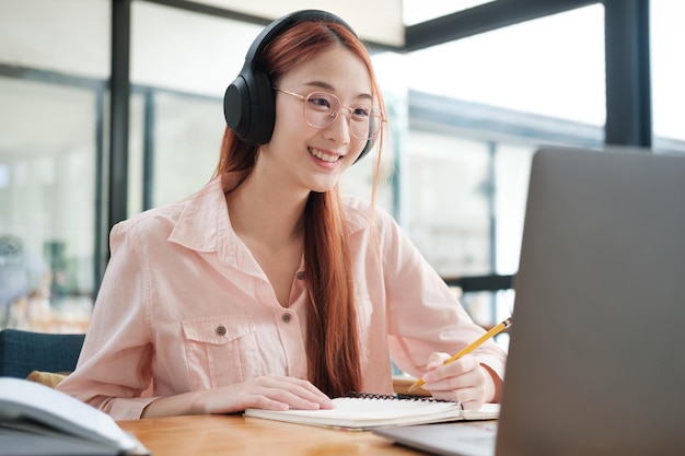 Young collage student using computer and mobile device studying online
