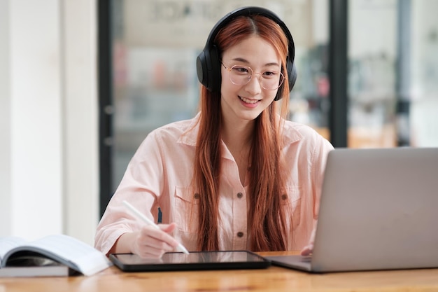 Young collage student using computer and mobile device studying online