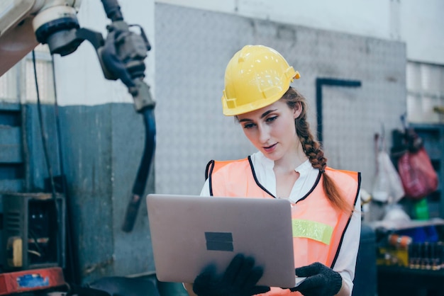 Young engineer using laptop at factory