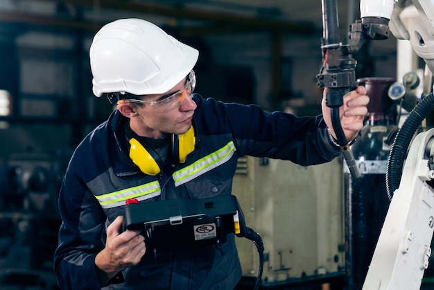 Young factory worker working with adept robotic arm
