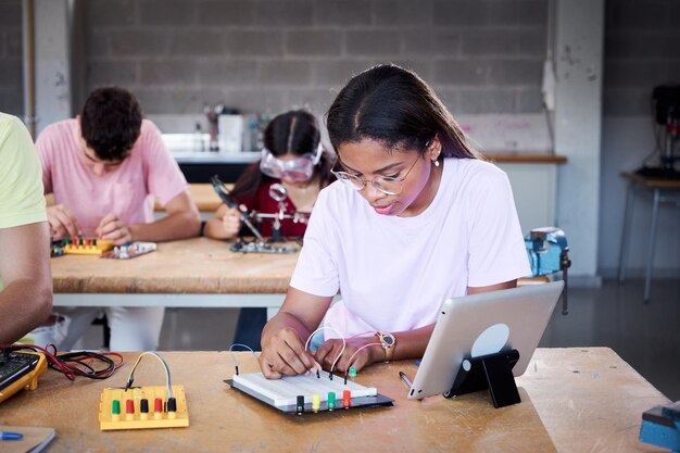 Young latin girl student at technical high school in classroom hardware parts on circuit boards