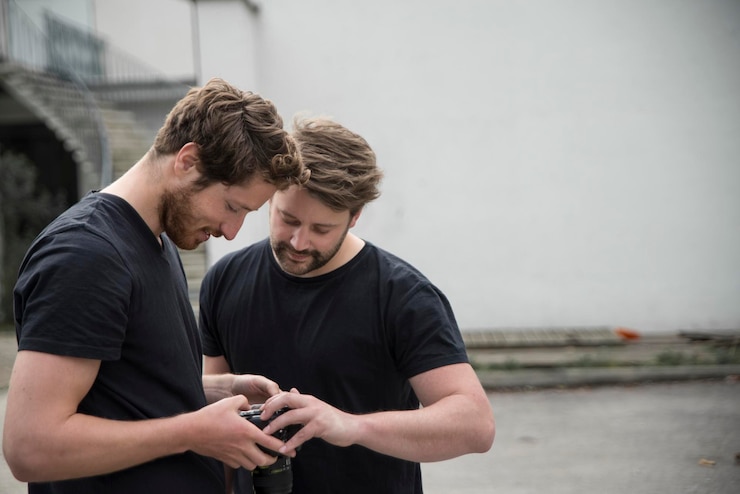 Kuva ystävät käyttävät digitaalikameraa jalkakäytävällä