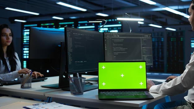 Zoom in on green screen laptop used by data center worker troubleshooting issues