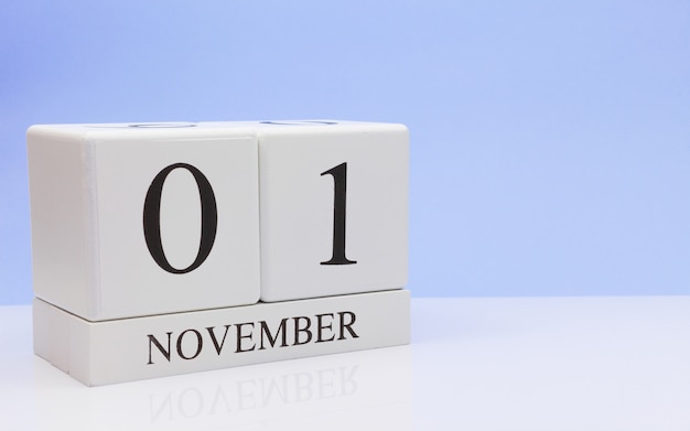 01 november. Dag 1 van de maand, dagelijkse kalender op witte tafel met reflectie