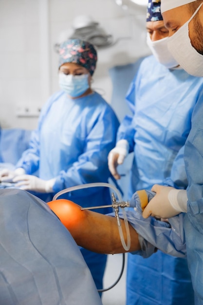 02012024 Vinnytsia Ukraine two trauma surgeons work on a patients knee joint reconstruction on the operating table