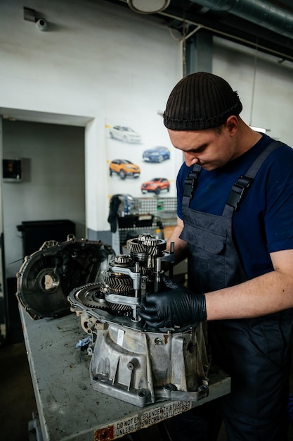 020124 Vinnitsa Oekraïne de jonge meester is bezig met de aanpassing en garantie reparatie van auto-onderdelen