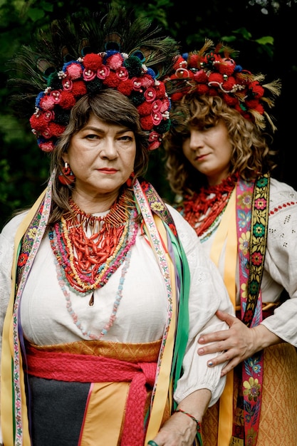 Photo 040622 vinnitsa ukraine two beautiful women mother and daughter wearing national embroidered ukrainian linen shirts and colorful necklace