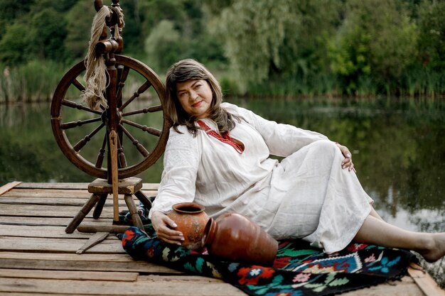 040622 Винница Украина женщина, позирующая для фото, одета в национальную украинскую одежду на фоне реки