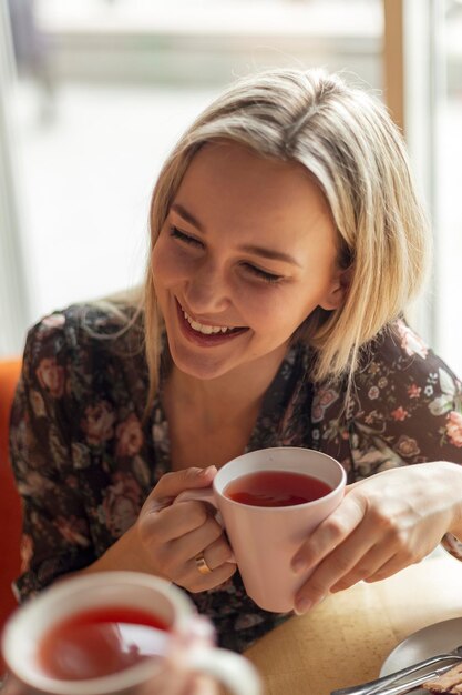 写真 05082019キーウウクライナおいしい熱いお茶のマグカップを持って飲んで楽しんで話している2人のきれいな女性