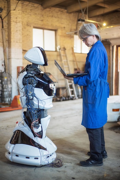 Photo 06 april 2019 russia novosibirsk the man assembles a humanlike robot and mends his hand