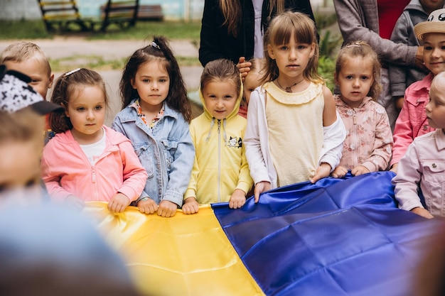 070722 Irpin Ukraine Christian kindergarten Children with the Ukrainian yellowblue flag in their hands pray for Ukraine and peace