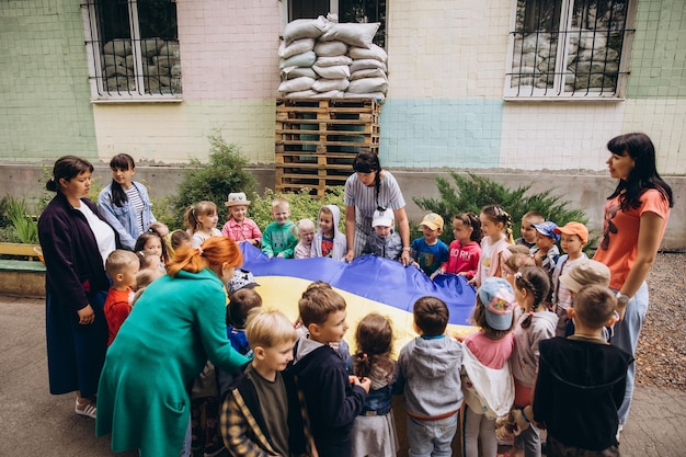 070722 Irpin Ukraine Kindergarten children play in the yard of the building which has a lining and a protected sandbag to protect against the blast wave Weekdays of Ukrainian children